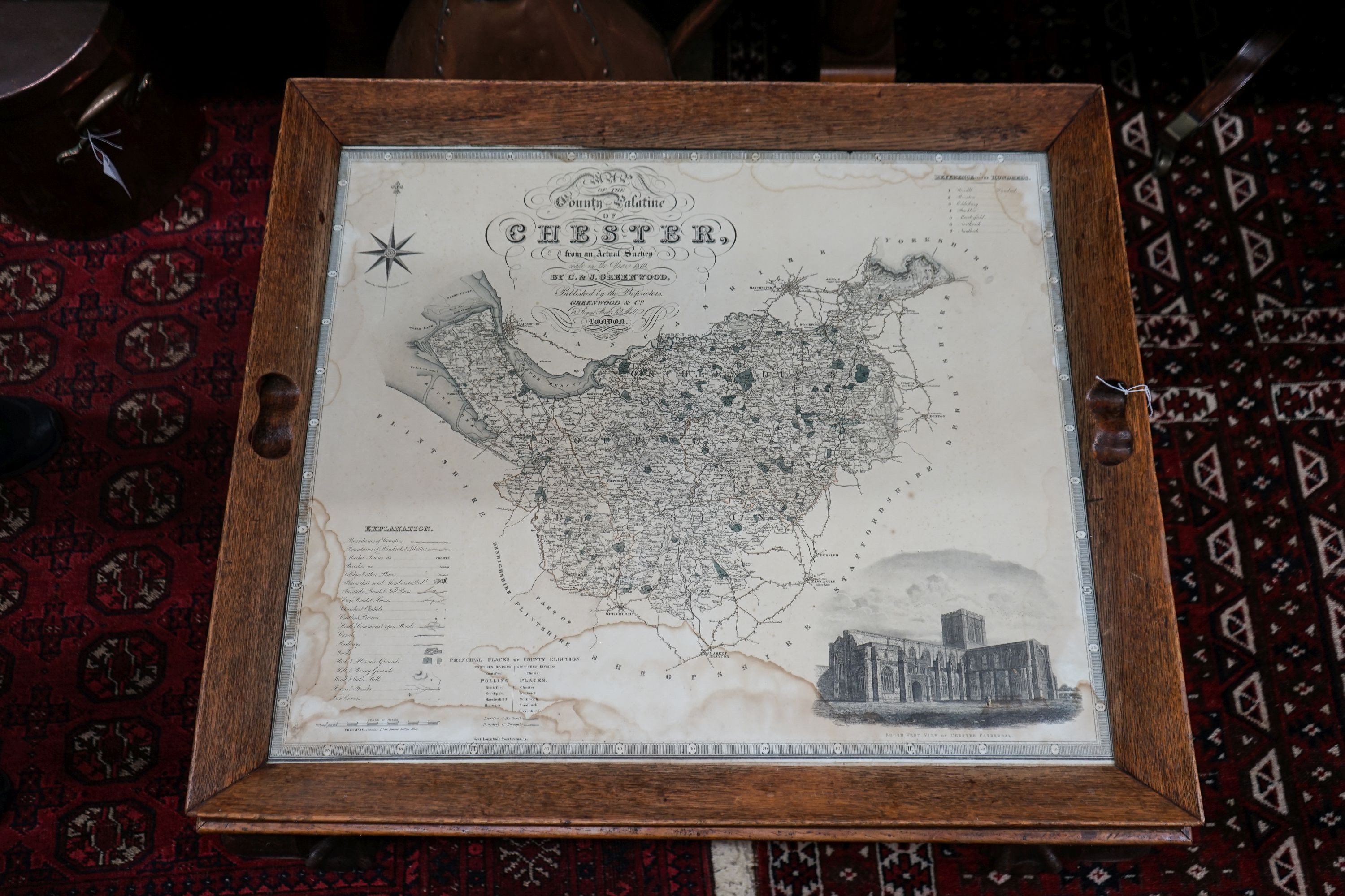 A rectangular oak tray top low table inset with a map of Cheshire on ball and claw stand, width 80cm, depth 70cm, height 48cm